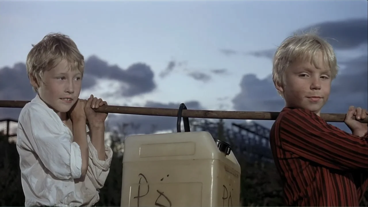 The Man Without a Past (2002) movie still: medium — Two young boys stand outdoors against a cloudy late afternoon sky. Each boy holds one end of a…