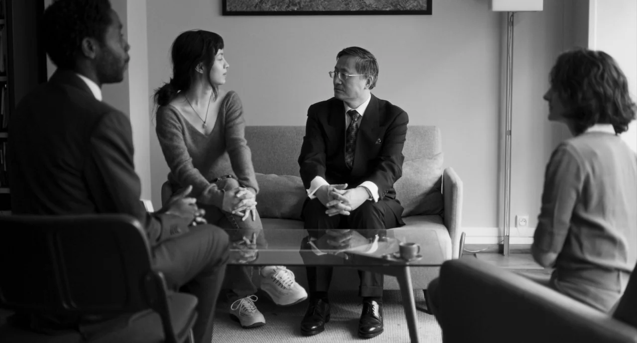 Paris, 13th District (2021) movie still: medium — A group of four adults sit in a residential space for a discussion. The arrangement centers on a…