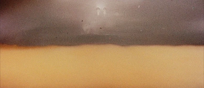 Jigoku (1960) movie still: establishing — A horizontal divide separates a dark upper sky from a vast warm desert landscape. The bright light source…