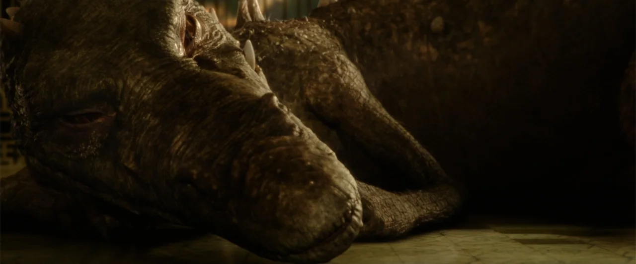 Jim Button and Luke the Engine Driver (2018) movie still: closeup — A dark stone room with ancient tiled floors contains a large reptilian creature.…