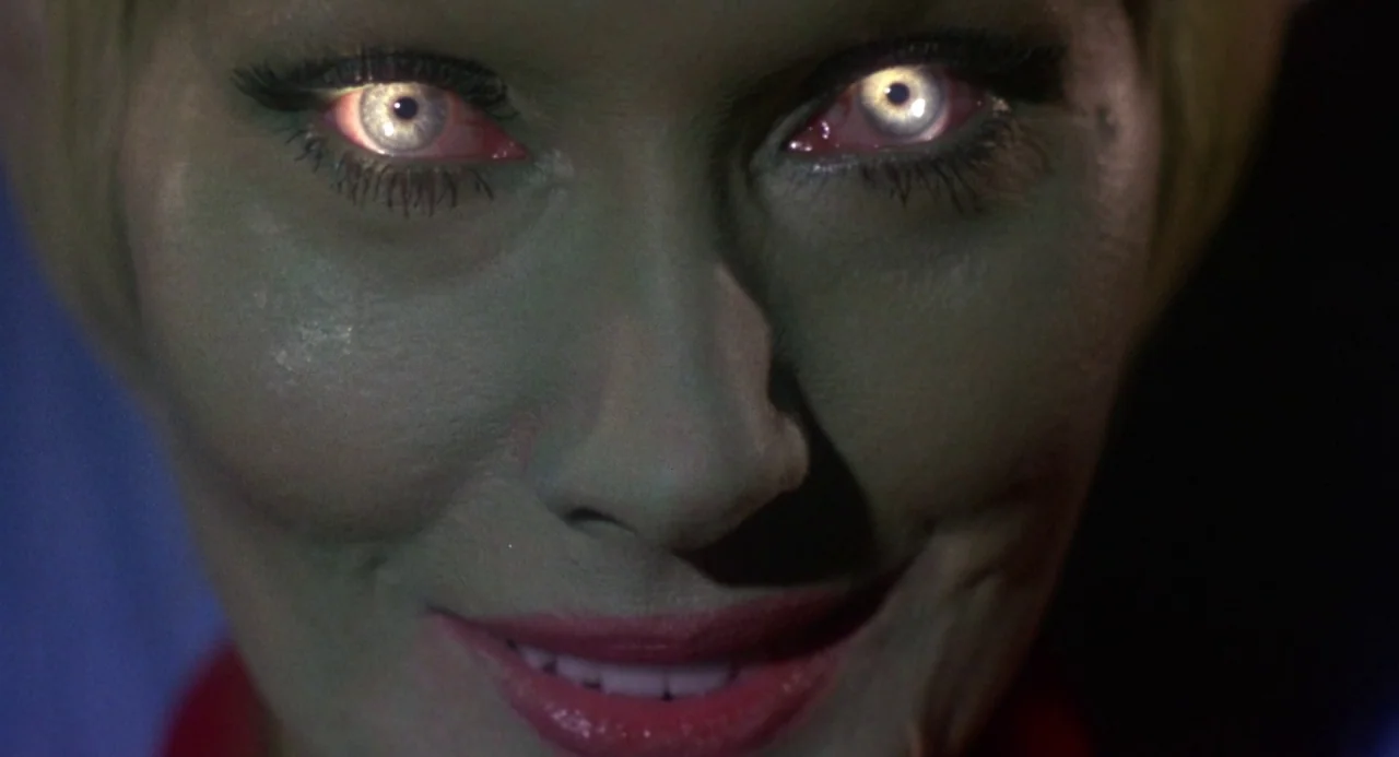 Queen of Blood (1966) movie still: closeup — A close-up of a person in a dark setting with no visible background details. The subject stares ahead…