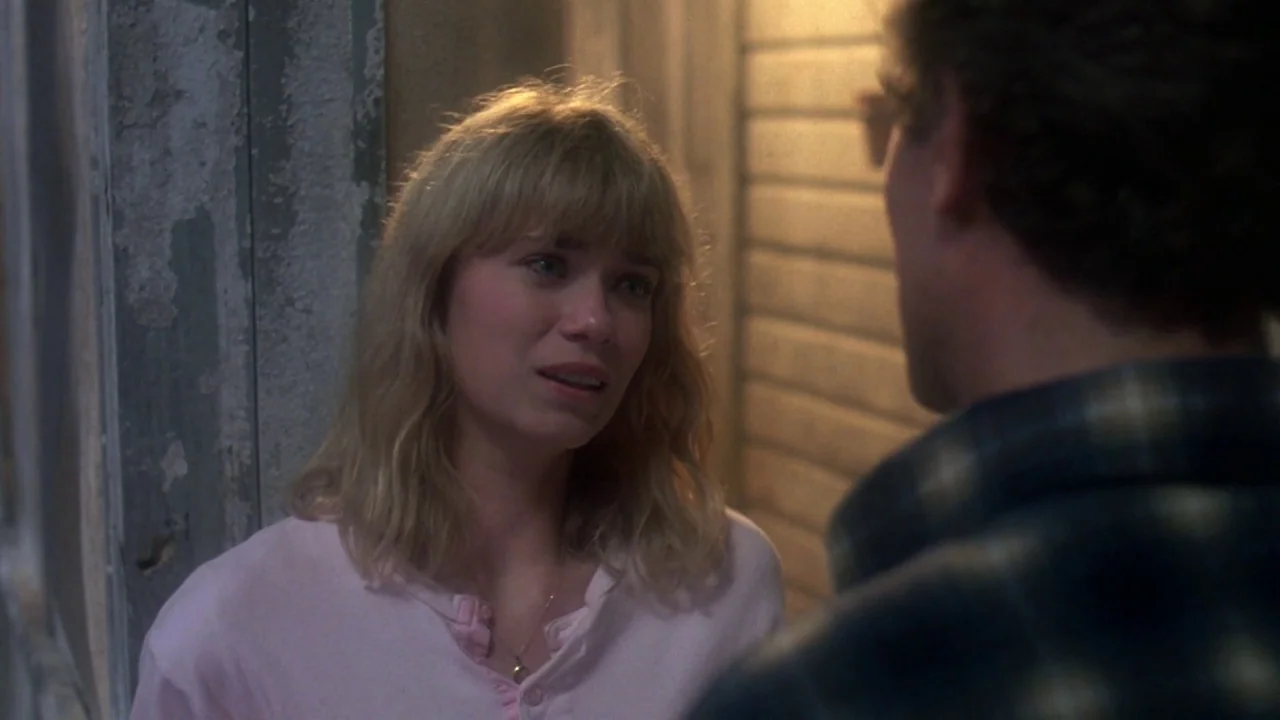Friday the 13th Part VII: The New Blood (1988) movie still: medium — A dimly lit exterior porch area features a weathered wooden post and wall. The…