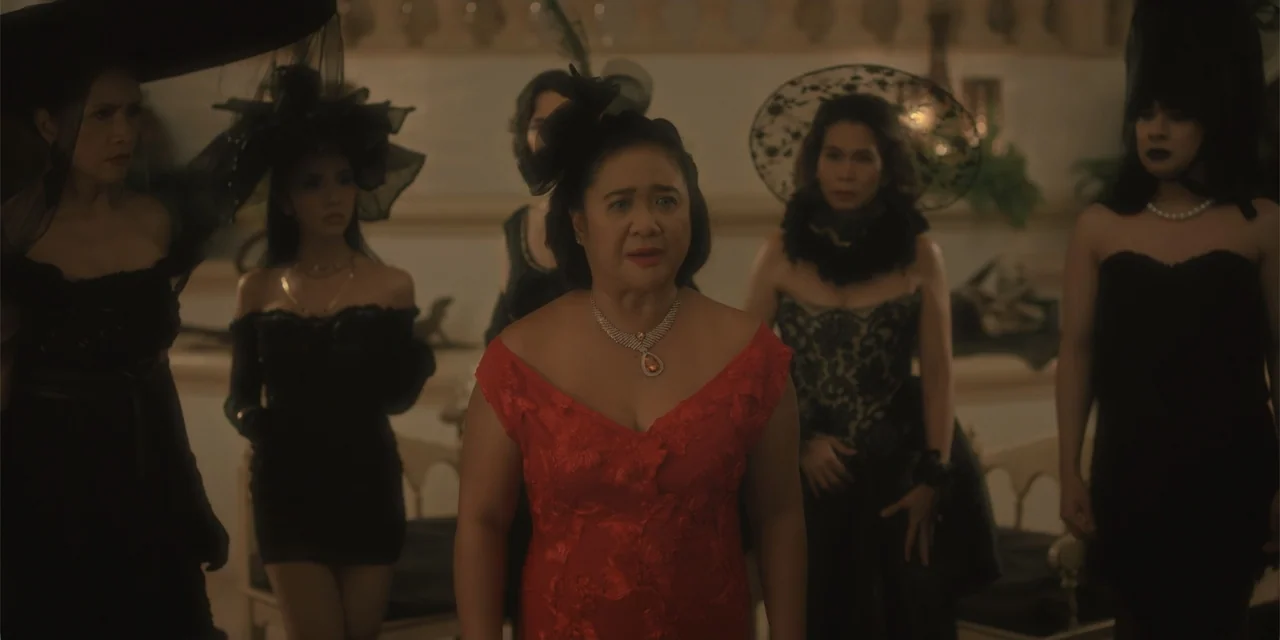 Ten Little Mistresses (2023) movie still: medium — An interior space with pale walls and architectural molding forms the background. Five women…