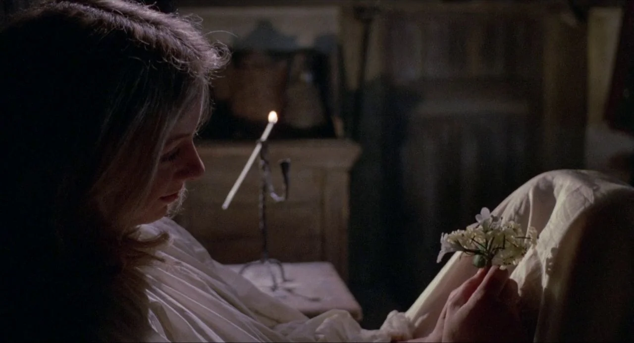 The Blood on Satan’s Claw (1971) movie still: closeup — A dimly lit room at night with antique furnishings visible in the dark background. A young…
