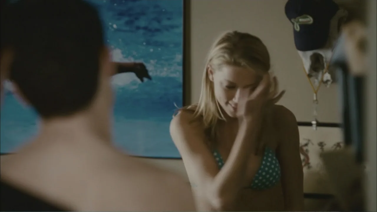 The Stepfather (2009) movie still: medium — An interior bedroom with a blue ocean print on the wall. A woman in a bikini is partially visible while…