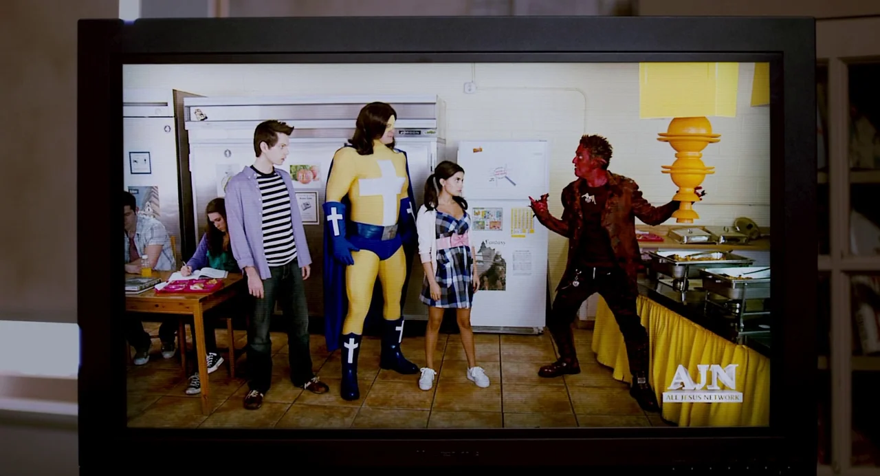 Super (2010) movie still: wide — A cafeteria area features large white refrigerators and food service tables with yellow skirts. A superhero, a…