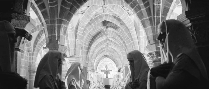 Marketa Lazarová (1967) movie still: medium — The stone interior of an ancient vaulted cathedral features rows of archways. Multiple nuns in…
