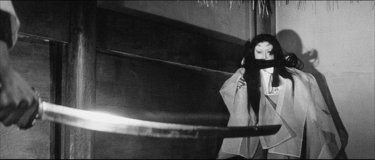 Kuroneko (1968) movie still: medium — A sparsely decorated room with dark wooden walls and traditional paper screens. A woman in a robe stands…