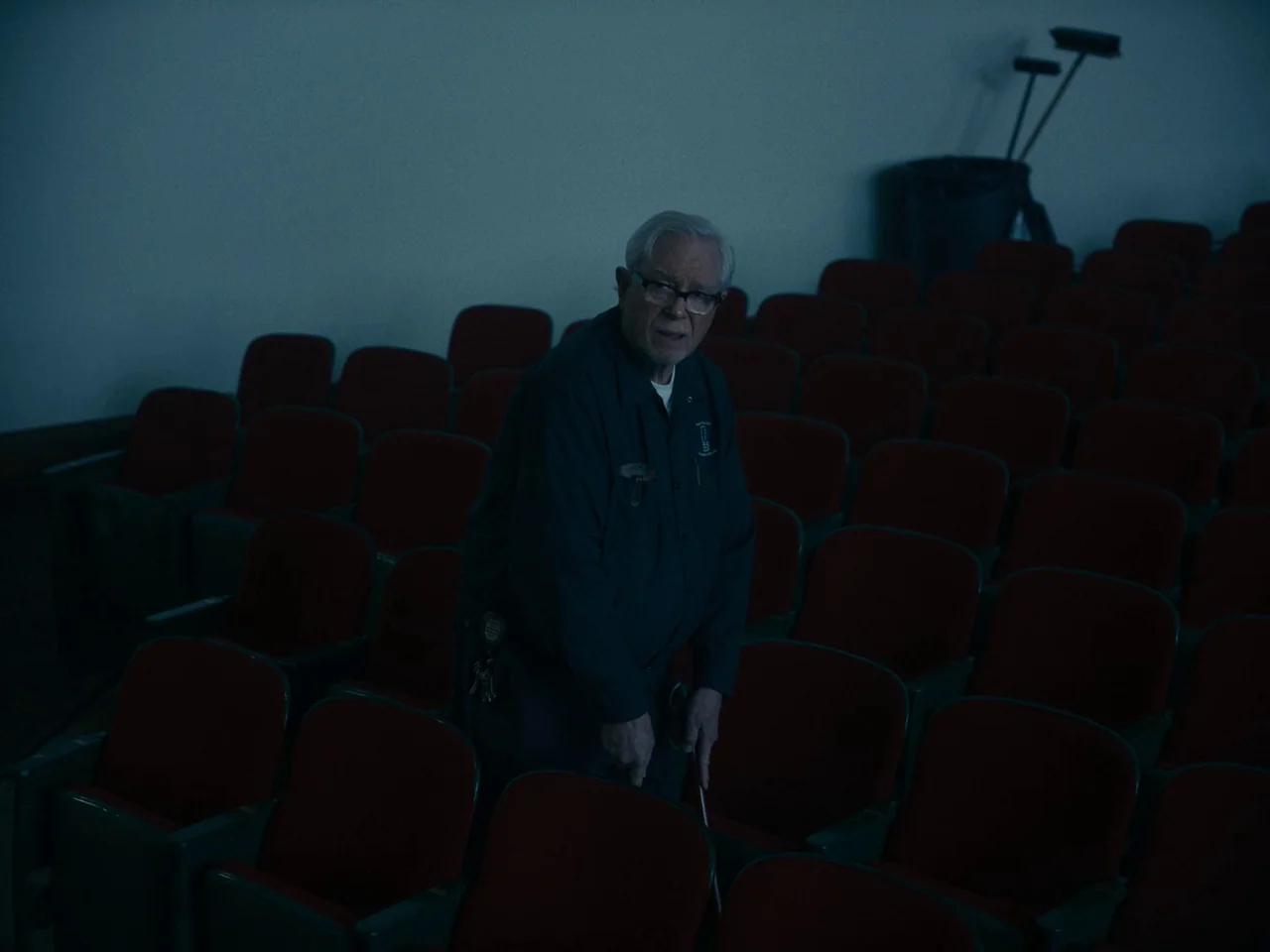 I’m Thinking of Ending Things (2020) movie still: medium — An empty, darkened auditorium features rows of red velvet seats arranged in tiers. An…
