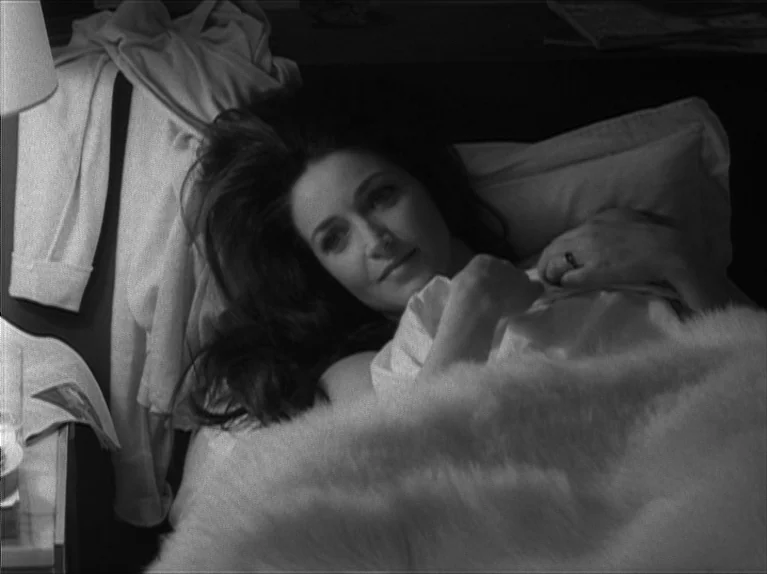 My Night At Maud’s (Ma Nuit Chez Maud) (1969) movie still: medium — A dark bedroom with soft linens and a lamp creating strong shadow contrasts. A…