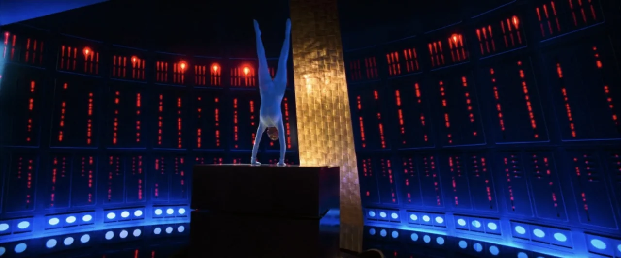 Charlie's Angels (2000) movie still: fullbody — A dark room features walls lined with glowing red and blue vertical indicator lights. A person in a…
