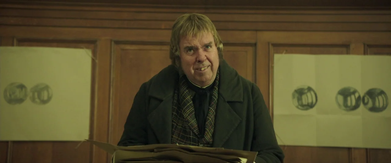 Mr. Turner (2014) movie still: medium — A room with wooden wall paneling and two paper charts pinned to the walls. An older man stands before the…