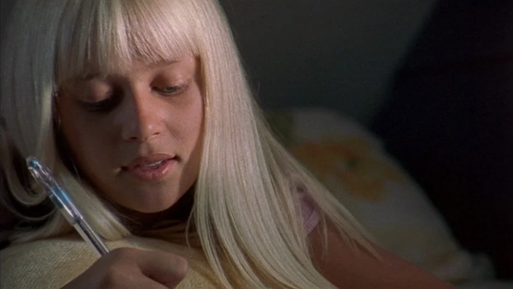Mean Creek (2004) movie still: closeup — A dimly lit room provides the backdrop for a young woman writing notes. She focuses intently on the task…