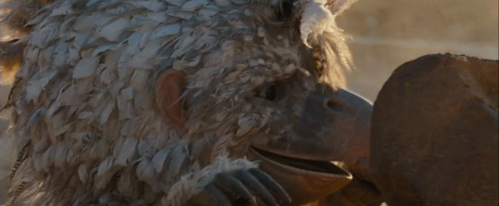 Where The Wild Things Are (2009) movie still: closeup — An avian fantasy creature sits outdoors in a desert landscape during the day. The creature…