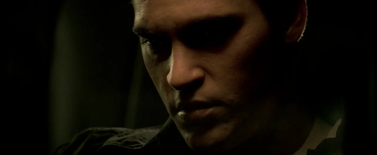 The Yards (2000) movie still: closeup — A dark car interior with minimal light hitting the subject's face. The subject looks down toward their chest…