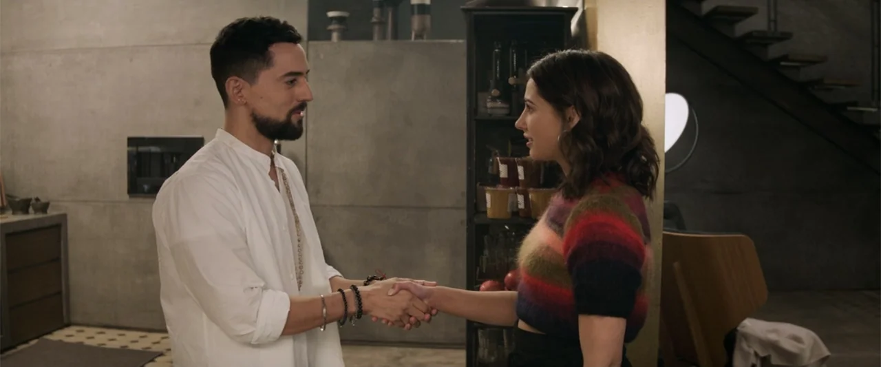 Charlie's Angels (2019) movie still: medium — A modern interior space features concrete walls and minimalist furniture in the background. A man and…