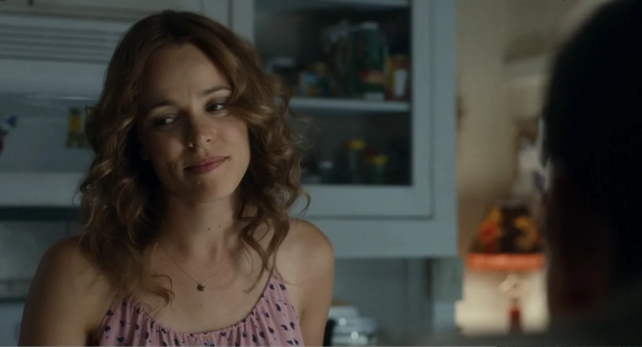 Aloha (2015) movie still: medium — A residential interior space features white cabinetry in the background under soft light. A woman wearing a pink…