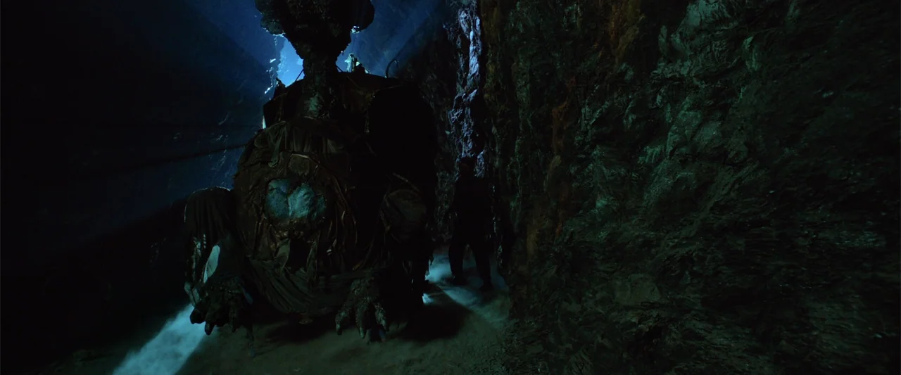 Jim Button and Luke the Engine Driver (2018) movie still: wide — A narrow, dark cave corridor features jagged, damp rock walls and floor mist. A…