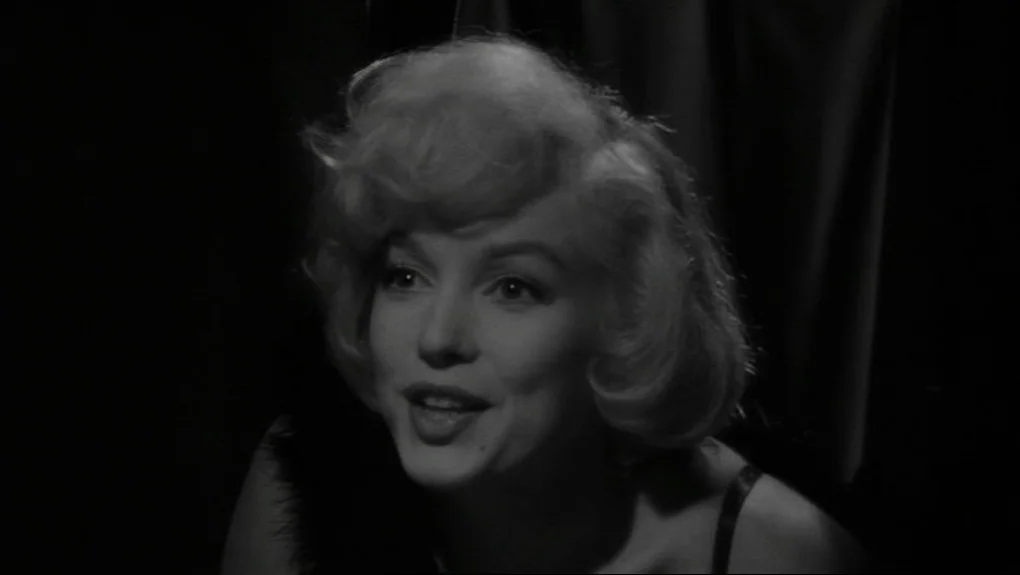 Some Like It Hot (1959) movie still: closeup — A dark space with a black backdrop frames the subject's upper body. A woman with platinum blonde hair…