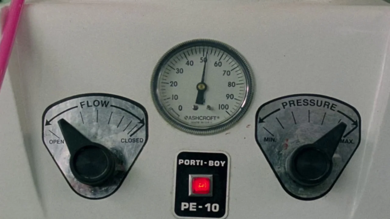 I Am Not a Serial Killer (2016) movie still: closeup — A white metal control panel for a Porti-Boy PE-10 embalming machine displays gauges. The…