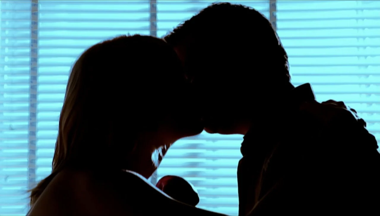 Dark Country (2009) movie still: medium — A dark bedroom interior features a bright window with closed horizontal blinds behind people. Two…