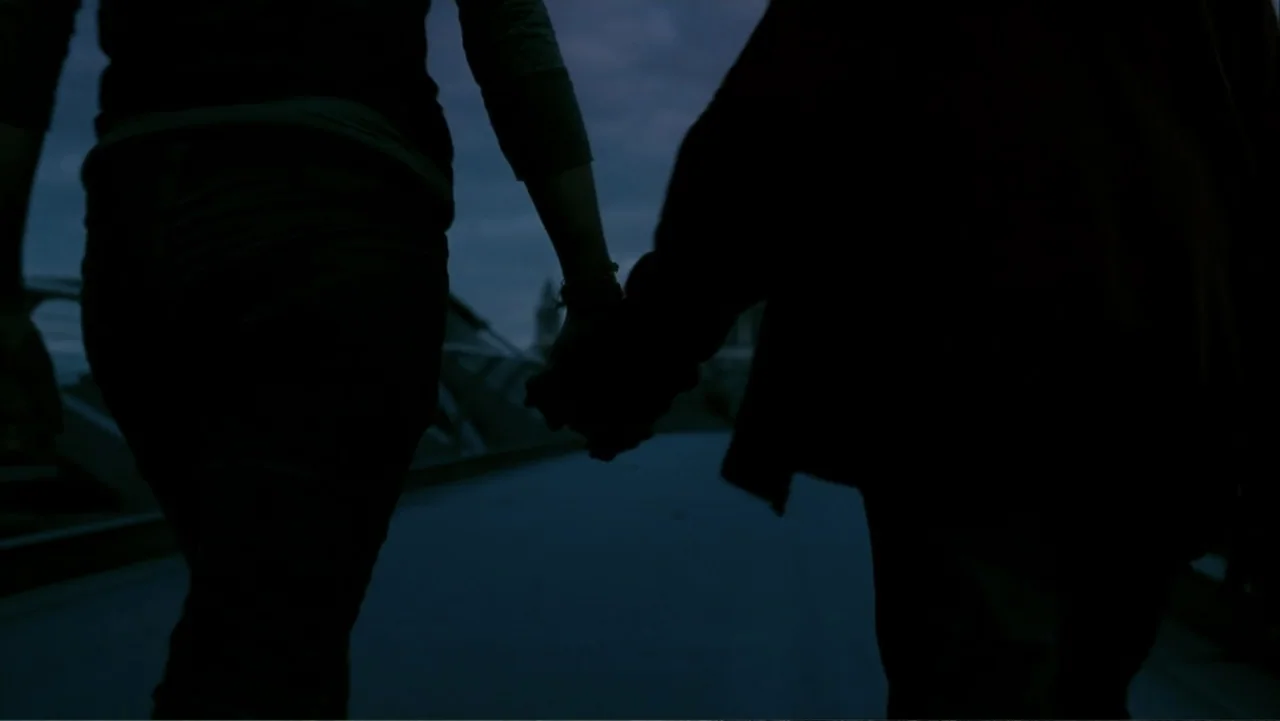 28 Weeks Later (2007) movie still: medium — A pedestrian bridge at dusk provides the setting for two silhouetted figures. The pair walks away from…