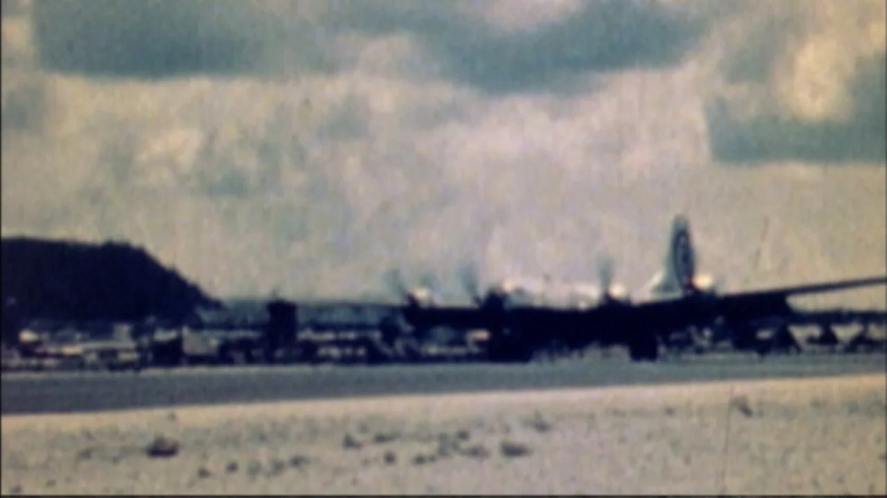 White Light/Black Rain: The Destruction of Hiroshima and Nagasaki (2007) movie still: wide — A wide, grainy shot of an airport runway on an overcast…