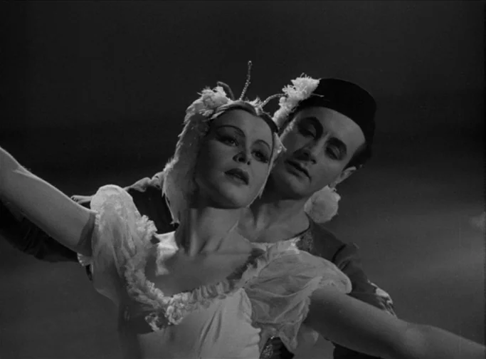 Summer Interlude (1951) movie still: medium — A dark stage with two ballet dancers illuminated by a spotlight. A woman in a feathered white costume…
