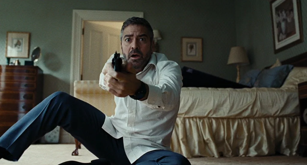 Burn After Reading (2008) movie still: medium — A furnished interior space with light-colored walls and traditional furniture like a lamp.
