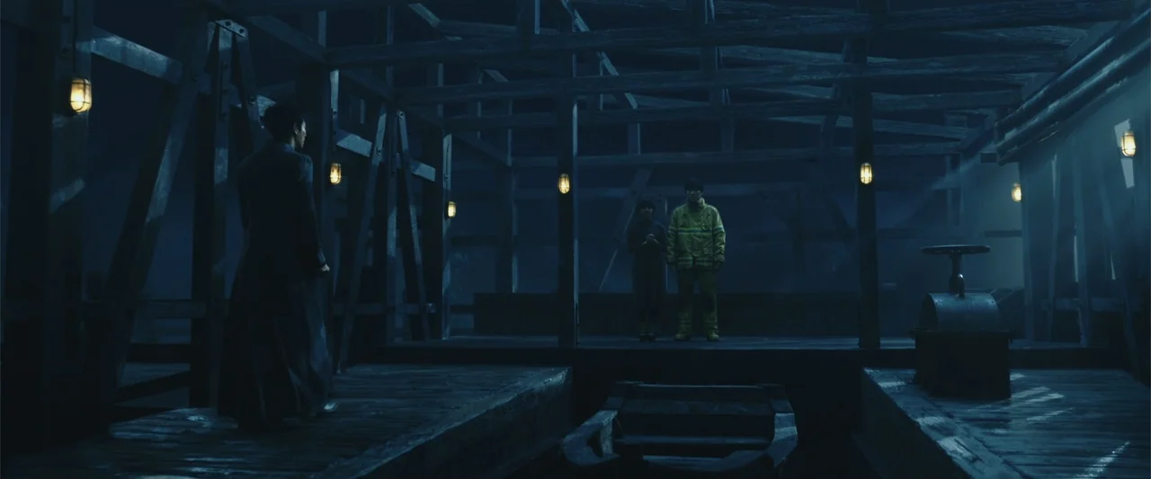 Along with the Gods: The Two Worlds (2017) movie still: wide — A dark wooden pier structure features exposed beams and dim wall-mounted cage lamps.…