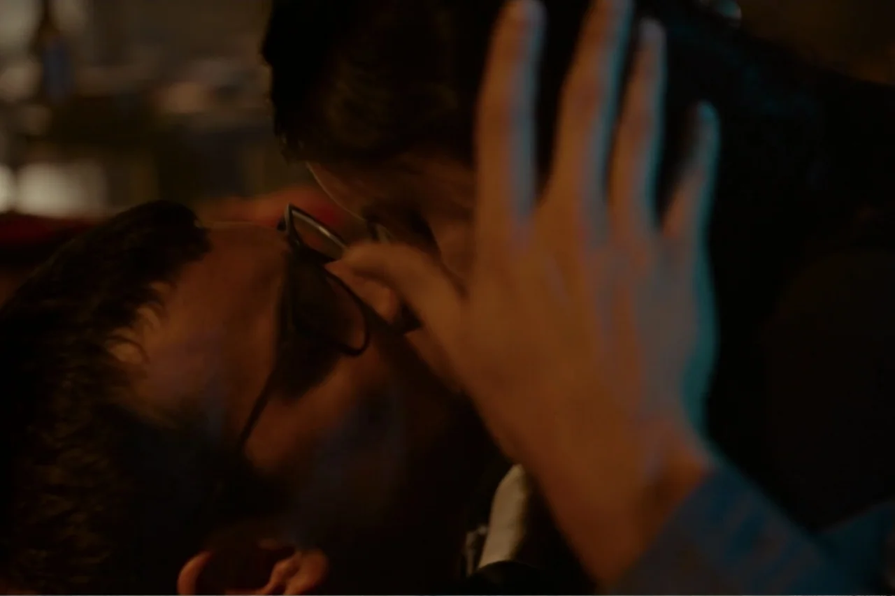 Cross the Line (2020) movie still: closeup — A dimly lit room provides the backdrop for a close-up interaction between two people. Two individuals…