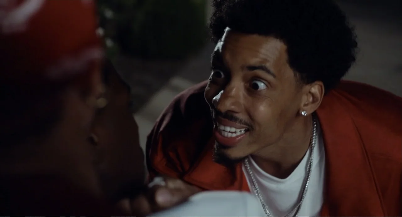 House Party (1990) movie still: medium — Two men are positioned closely together in a dark outdoor space at night. The man in focus smiles with wide…