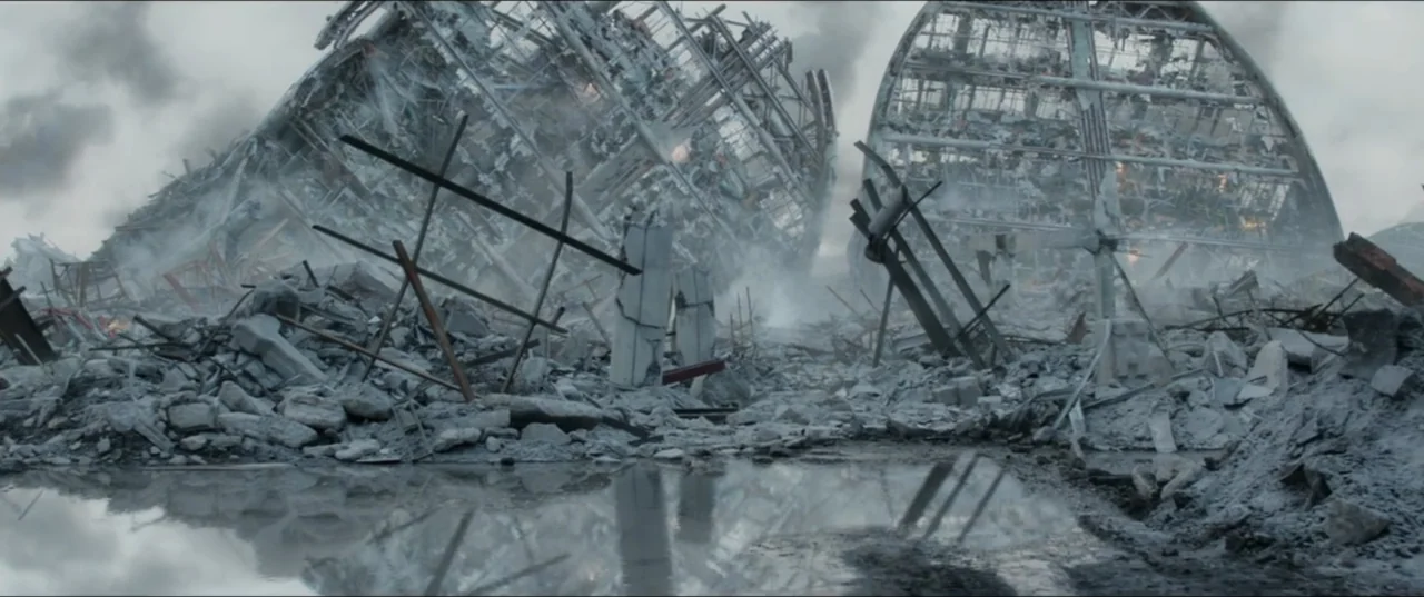 Terminator Genisys (2015) movie still: establishing — A decimated urban landscape features two collapsed arched structures made of metal and…