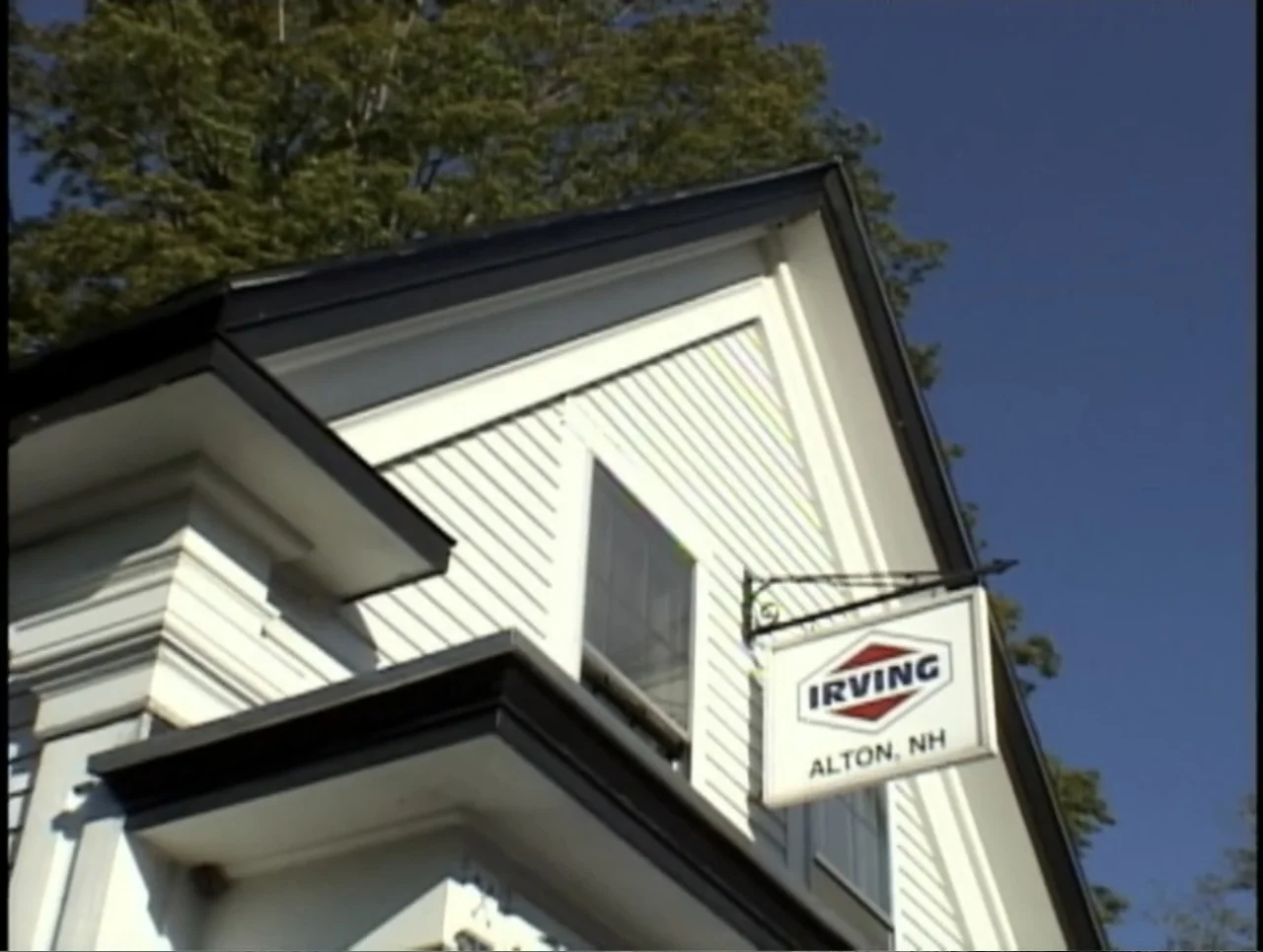 A Rape in a Small Town: The Florence Holway Story (2005) movie still: wide — A white building with dark trim sits under a bright blue sky. An Irving…