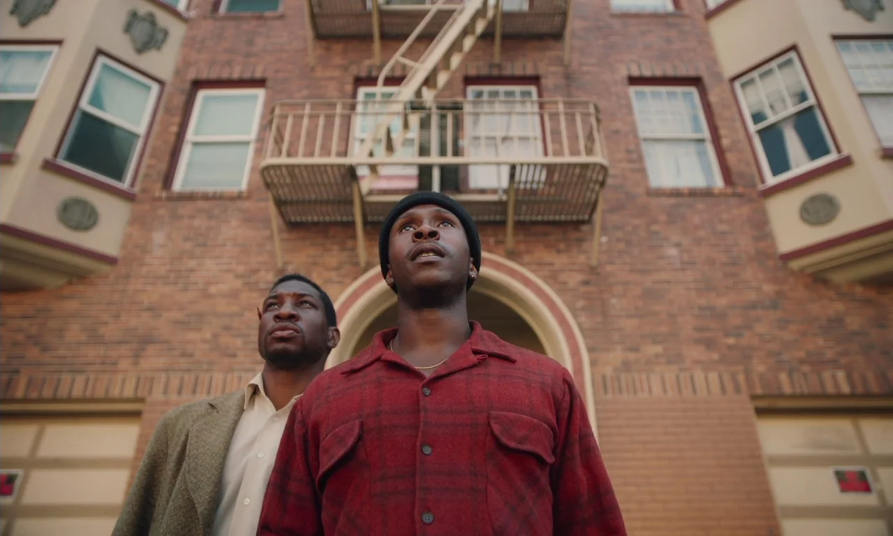 The Last Black Man in San Francisco (2019) movie still: medium — A multi-story brick residential building features a prominent metal fire escape and…