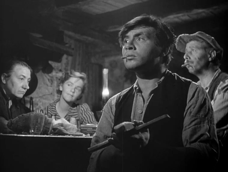 Forbidden Games (1952) movie still: medium — A dimly lit indoor space with rustic wooden surfaces and a small central lamp. A group of four adults…
