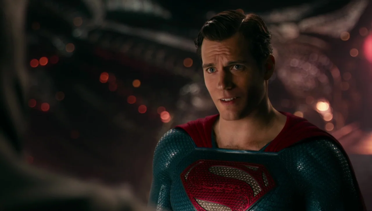 Justice League (2017) movie still: medium — A dark, alien environment with metallic organic textures and distant red glowing lights. A muscular man…
