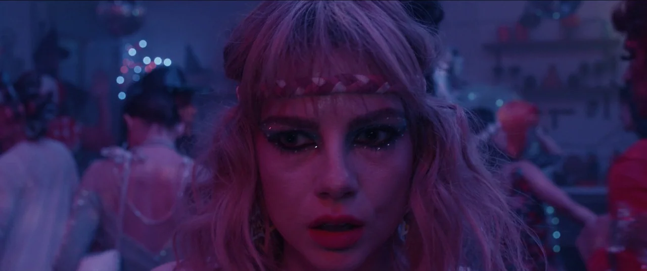 The Greatest Hits (2024) movie still: closeup — A crowded nightclub interior features indistinct figures moving in the dark background. A young…