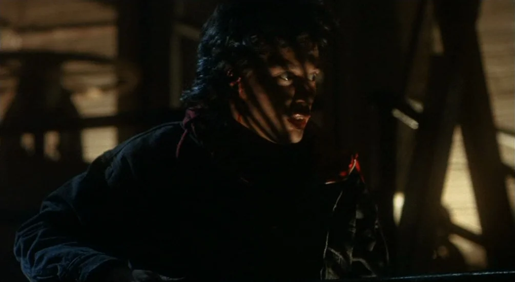 Freddy’s Dead: The Final Nightmare (1991) movie still: medium — A dark, cluttered attic space contains wooden structures illuminated by harsh,…
