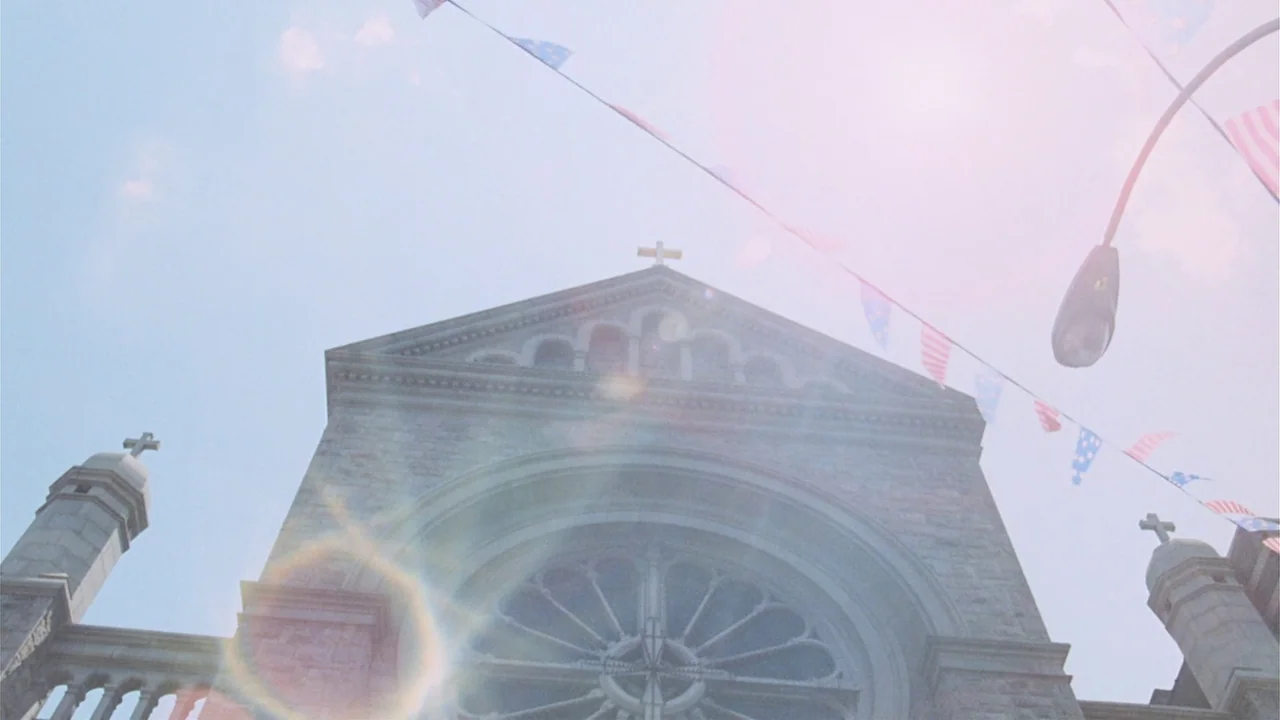 The Sentinel (1977) movie still: establishing — A stone cathedral exterior features a large rose window and decorative cross spires. A string of…