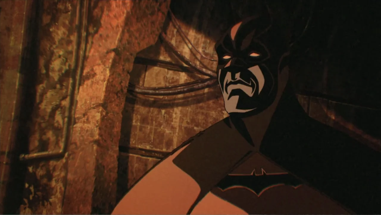 Batman: Gotham Knight (2008) movie still: medium — An industrial space features aged brick walls and visible conduit pipes. A masked figure in a…