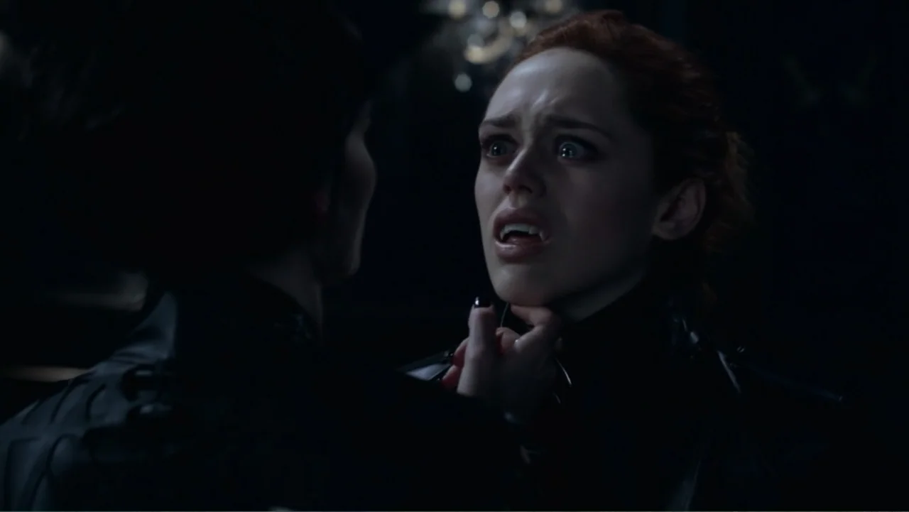Underworld: Blood Wars (2016) movie still: closeup — A dark, dimly lit indoor space with obscured background details. A person holds another by the…