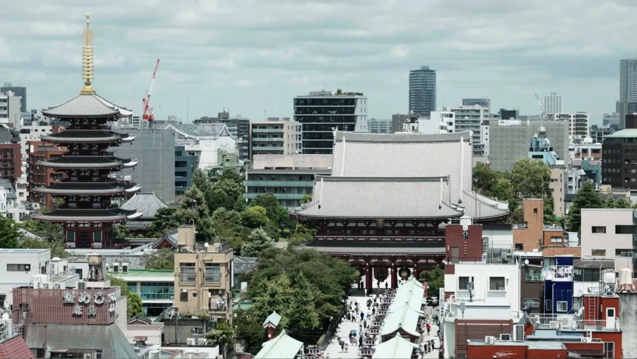 Vai Corinthians (2023) movie still: establishing — An aerial view captures the Senso-ji temple grounds surrounded by a dense modern cityscape.…