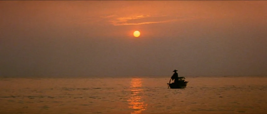 Lone Wolf and Cub: Baby Cart in the Land of Demons (1973) movie still: wide — A vast expanse of water reflects the light of a setting sun. A lone…