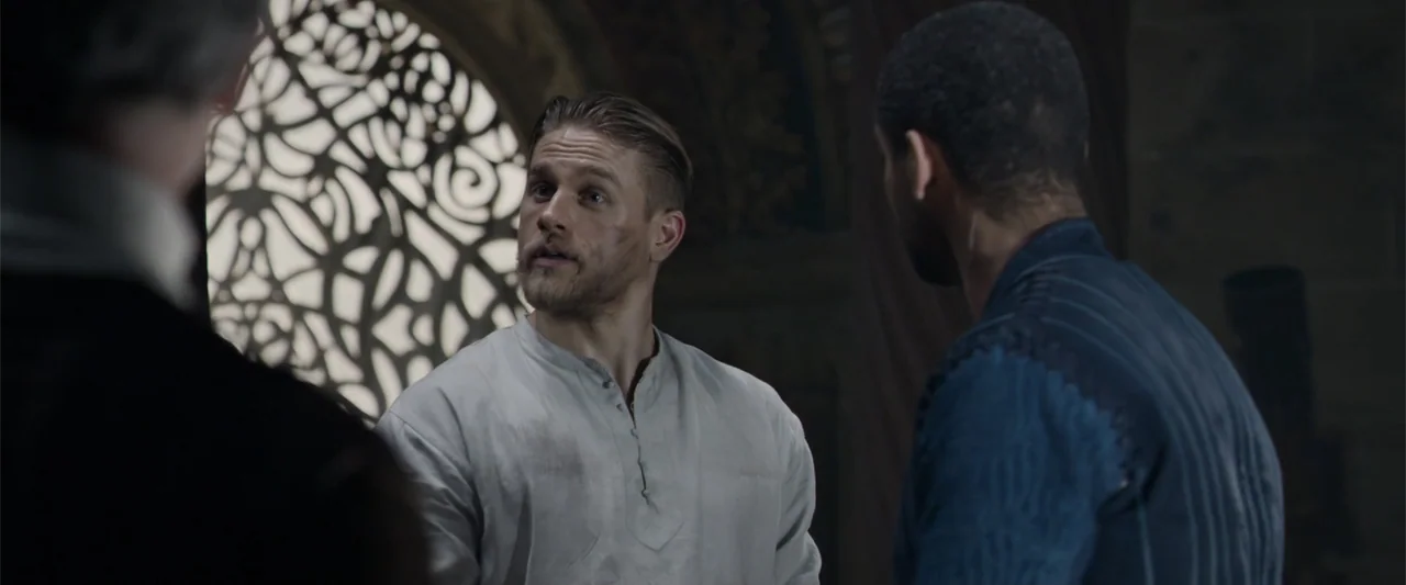 King Arthur: Legend of the Sword (2017) movie still: medium — A stone castle interior features a large intricate circular window with stone tracery.…