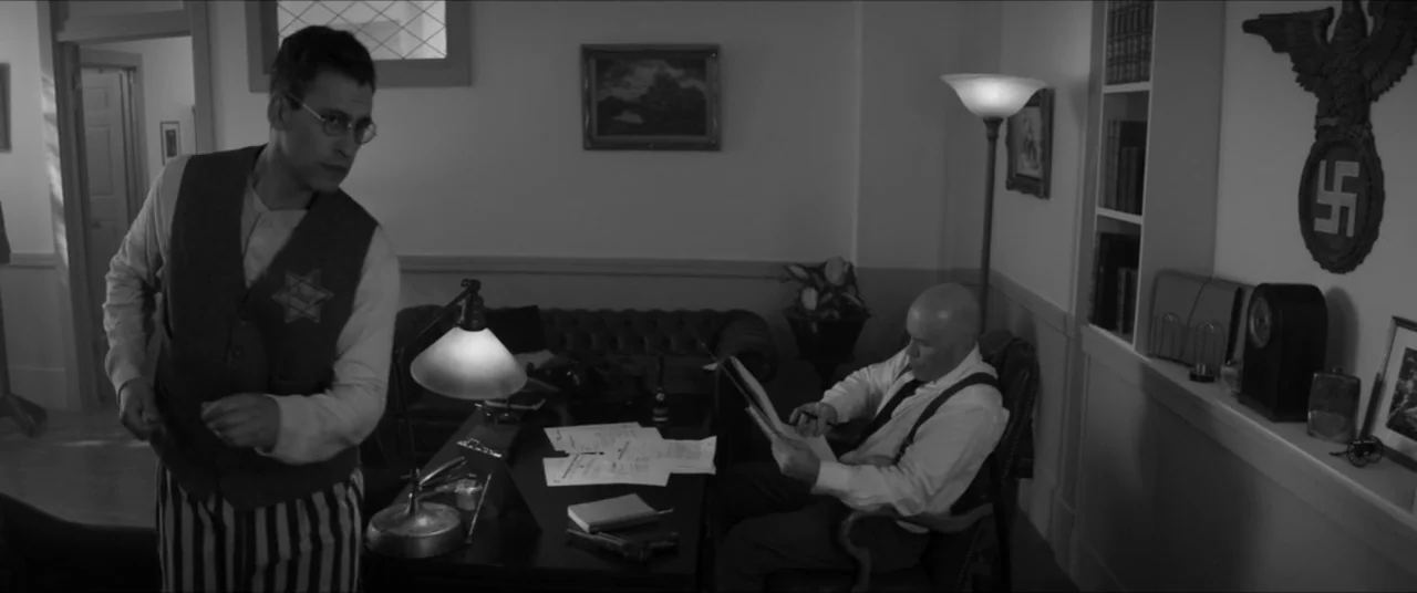 Bau, Artist at War (2025) movie still: medium — An interior office from the 1940s featuring a desk, leather seating, and a Nazi eagle emblem mounted…