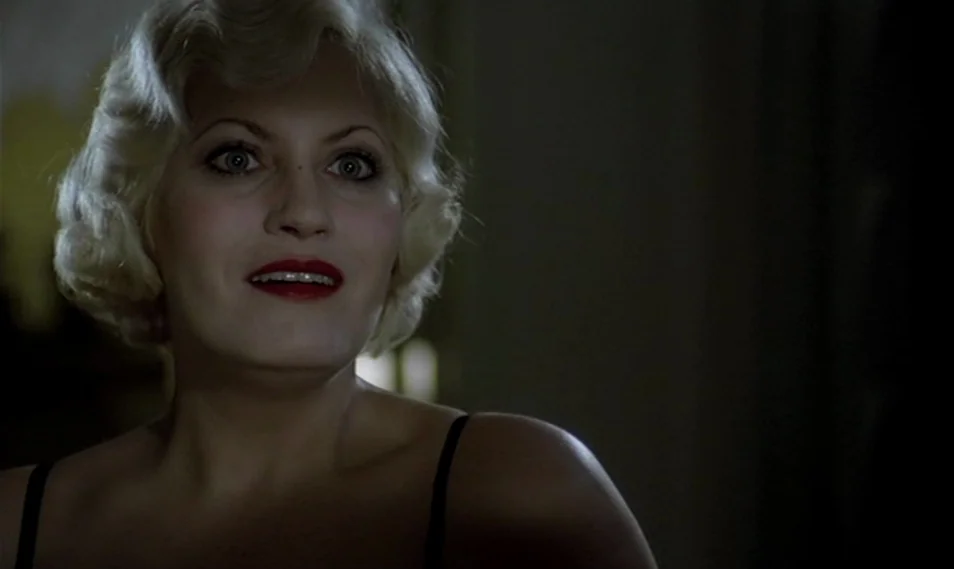 Despair (1978) movie still: closeup — A dark indoor space serves as the backdrop for a portrait of a woman. A blonde woman with vintage hairstyle…