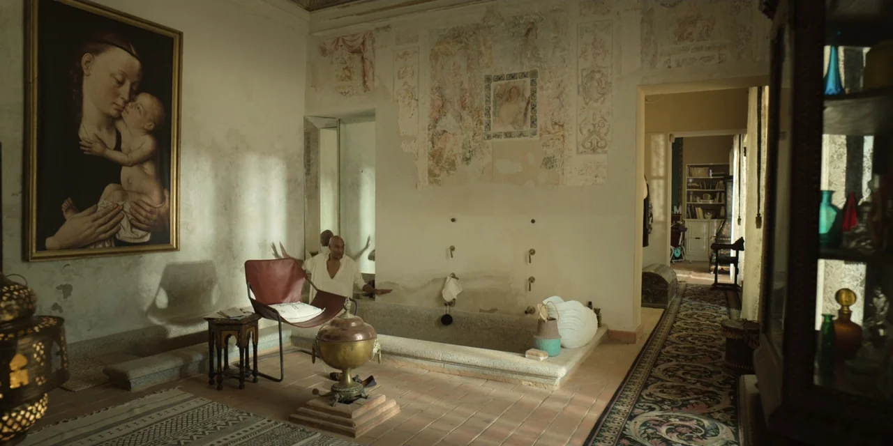 The Three Wise Men: The Truth (2022) movie still: wide — An opulent interior space features a stone basin and faded wall frescoes. A man in a light…