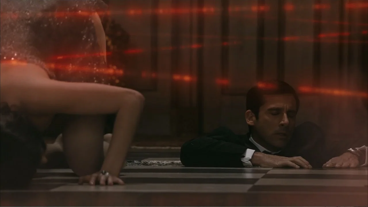 Get Smart (2008) movie still: medium — A polished dark floor spans a room illuminated by intersecting thin red laser beams. A man in a suit lies…