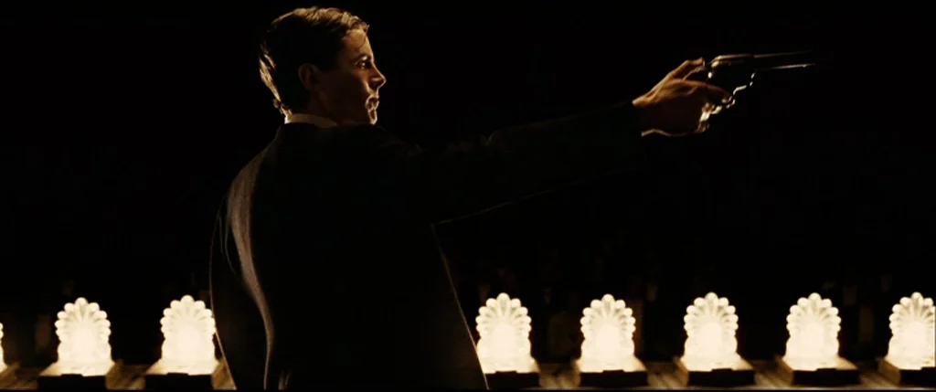 The Assassination Of Jesse James By The Coward Robert Ford (2007) movie still: medium — A dark theater features a row of lit, fan-shaped…